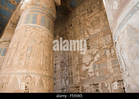 Colonne nell'antico tempio egizio di Medinat Habu a Luxor con sculture in geroglifico Foto Stock