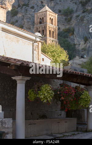 Vecchio lavatoio in primo piano, antica chiesa romanica di Moustiers-Sainte-Marie, Notre-Dame-de-l'Assomption Foto Stock