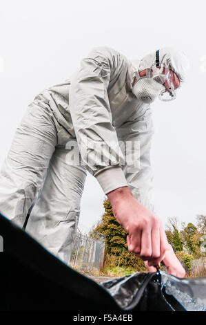 Una scena del crimine Officer (SOCO) indossare la maschera protettiva e occhiali cerniere un sacco di corpo (punto di vista da dentro il sacco) Foto Stock