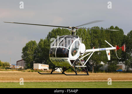 Schweizer 269C 300 G-BSVR hover rullaggio lungo la pista di atterraggio di Aviosuperficie Breighton Foto Stock