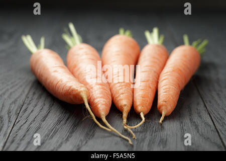 Le carote fresche sul vecchio tavolo in legno di quercia Foto Stock