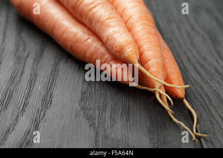 Le carote fresche sul vecchio tavolo in legno di quercia Foto Stock