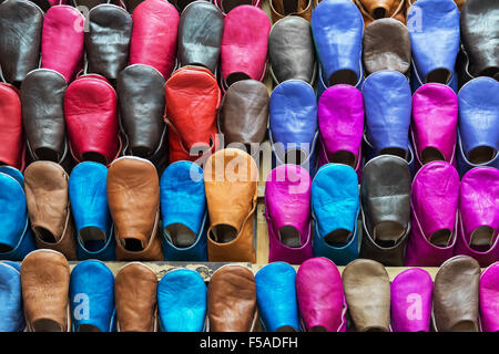 Colorate babouches marocchino visualizzato su una mensola a muro in un negozio a Marrakesh, Marocco. Foto Stock