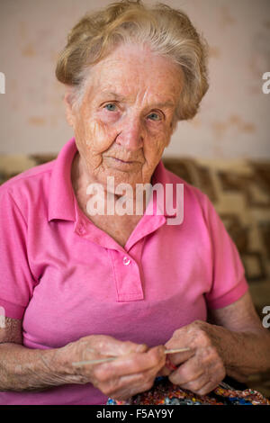 Ritratto di donna senior mani di maglia. Foto Stock