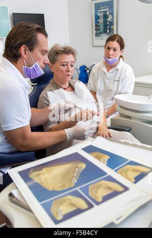 Studio dentista, dentista, assistente e pazienti anziani, trattamento dentale, prevenzione, esame, check up, dentiere modello, Foto Stock