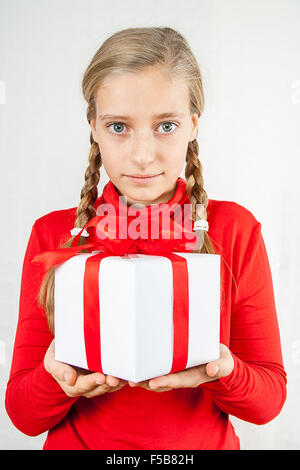 Bionda carina ragazza adolescente in rosso con confezione regalo Foto Stock