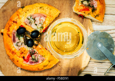 Vino bianco wineglass e pizza sul tavolo vista superiore Foto Stock