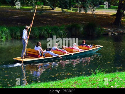 Un pugno di abbigliamento edoardiano che inpolava un gruppo di visitatori lungo il fiume Avon attraverso i Giardini Botanici, Christchurch, Nuova Zelanda Foto Stock