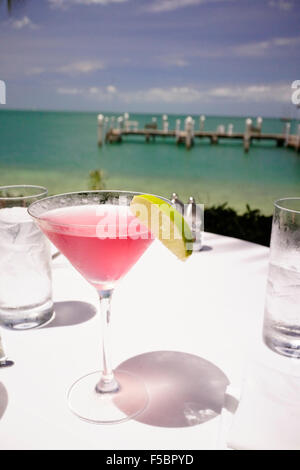 Le latitudini ristorante sul tramonto chiave, Key West, Florida, Stati Uniti d'America - drink cosmopolita con calce con darsena in background. Foto Stock