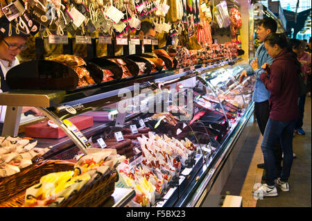 Bancarelle che vendono prosciutto nel mercato La Boqueria Barcellona Catalonia Spagna ES Foto Stock