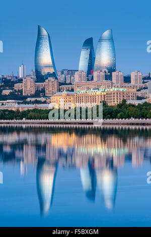 Le torri a fiamma riflessa nelle acque della baia di Baku all'alba. Foto Stock