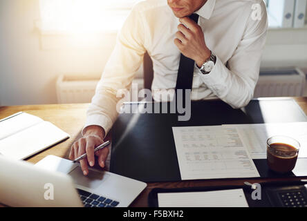 Business uomo che lavora in ufficio con il computer portatile e i documenti sulla sua scrivania, consulente avvocato concetto Foto Stock