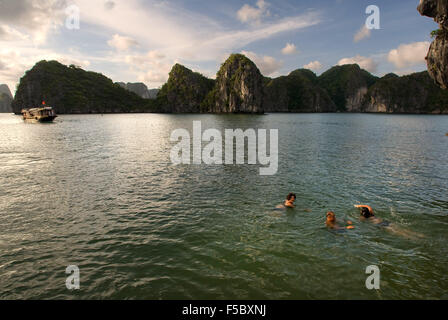 Persone swmming in spiaggia appartata nell isola nella baia di Ha Long, Vietnam. Tranquilla spiaggia tropicale, Cat Ba National Park, Ha long Foto Stock