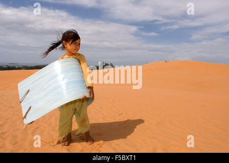 Mui Ne, Vietnam. Ragazza giovane con la slitta di sabbia per il noleggio presso le bianche dune di sabbia. Asia, fuori, dune, scenario, Mui Mui, Ne, natura, Foto Stock