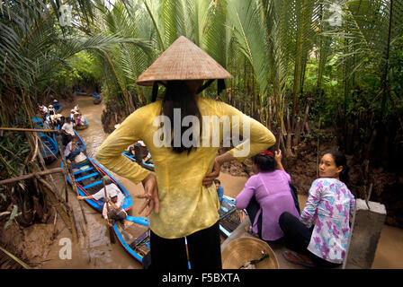 Donna e barche a remi sul fiume Mekong, vicino a My Tho village, Vietnam. Bao Dinh canale, delta del Mekong. La donna a non conica hat Foto Stock