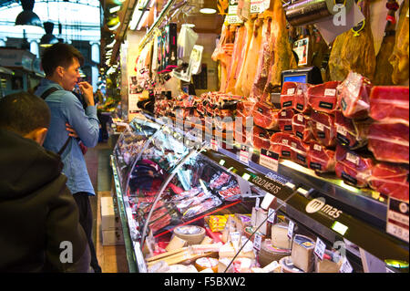 Bancarelle che vendono prosciutto nel mercato La Boqueria Barcellona Catalonia Spagna ES Foto Stock