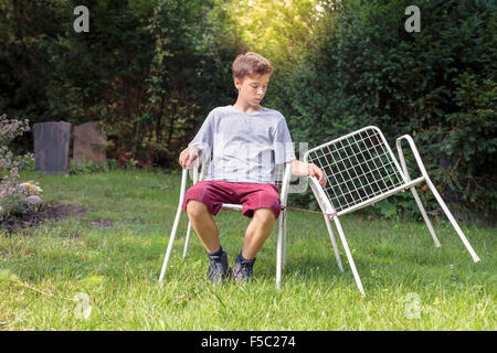 Lonely ragazzo adolescente con due sedie Foto Stock