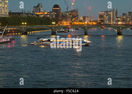 MBNA Thames Clippers (ex sponsor di Thames Clippers) con partenza dal London Eye Waterloo Pier e Lambeth Bridge sullo sfondo. Scena notturna Foto Stock