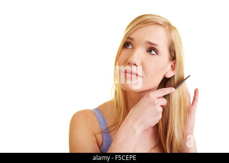 Giovane donna bionda con cautela la sua pettinatura dei capelli lunghi Foto Stock