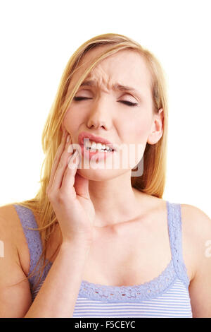 Giovane donna bionda con il mal di denti tenendo la sua guancia Foto Stock