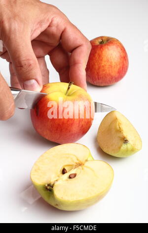 Chef che taglia a metà una mela gialla matura con un grosso coltello in  movimento. Spruzzi di acqua e succo volare in diverse direzioni e congelare  in aria Foto stock - Alamy