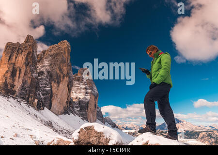 Sportivo da donna con il navigatore GPS in mano contro Dolomiti Alpi Foto Stock