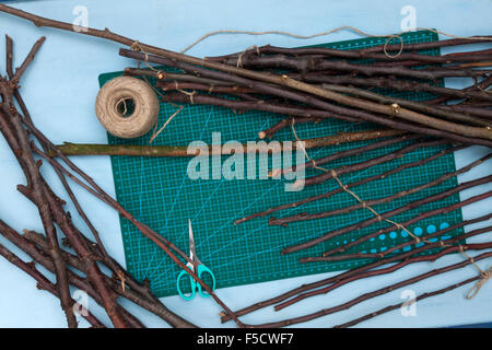 Una vista orizzontale di una artigianale di albero di Natale realizzati dai rami e alcuni degli oggetti di cui ha bisogno Foto Stock