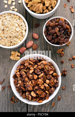 Muesli al cioccolato e gli ingredienti sul tavolo di legno, vista dall'alto Foto Stock