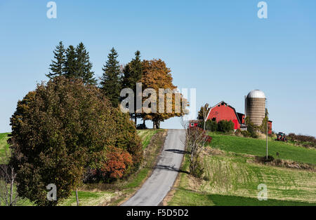 Granaio rosso e silo lungo una strada di campagna, Madison, New York, Stati Uniti d'America Foto Stock