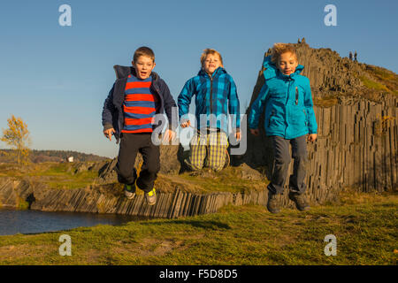 Bambini Ragazzi jumping con Panska skala rock formazione sfondo, natura geologica riserva Foto Stock