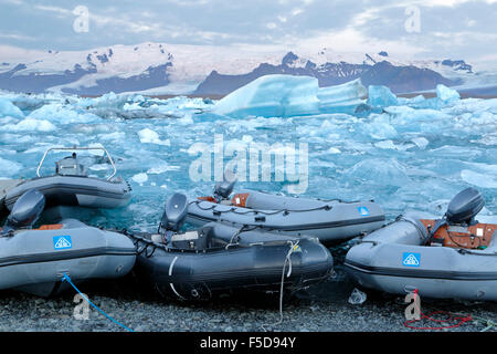 Canotti, iceberg e montagne coperte di neve, Jokulsarlon laguna glaciale, Vatnajokull National Park, Islanda Foto Stock