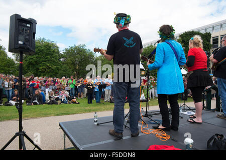 Le persone che giocano ukuleles presso la grande busk, parte dell'ukulele festival della Gran Bretagna a Cheltenham, Gloucestershire, Regno Unito Foto Stock