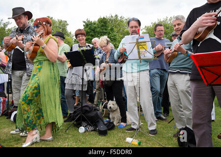Le persone che giocano ukuleles presso la grande busk, parte dell'ukulele festival della Gran Bretagna a Cheltenham, Gloucestershire, Regno Unito Foto Stock