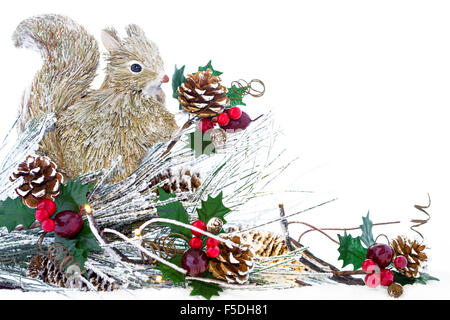 Una decorazione natalizia con legno di scoiattolo, le luci di Natale, pigne e bacche di Natale. Foto Stock