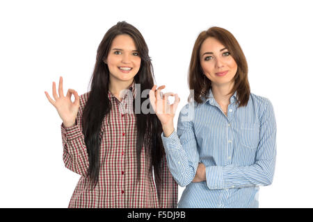 Due ragazze allegro fa segno OK con la mano Foto Stock