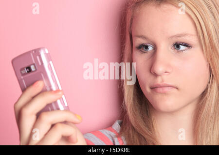 Ragazza adolescente utilizzare il cellulare in camera sua. Foto Stock