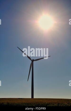 Un isolato turbina eolica vicino Steward, Illinois come il sole scende verso l'orizzonte dietro di esso. Steward, Illinois, Stati Uniti d'America. Foto Stock