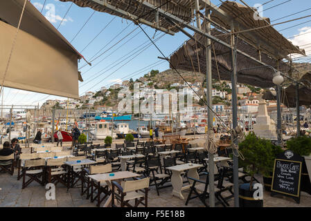 HYDRA, Grecia - 25 ottobre 2015: persone nei terrazzi di caffè sulla banchina del porto di Hydra Foto Stock