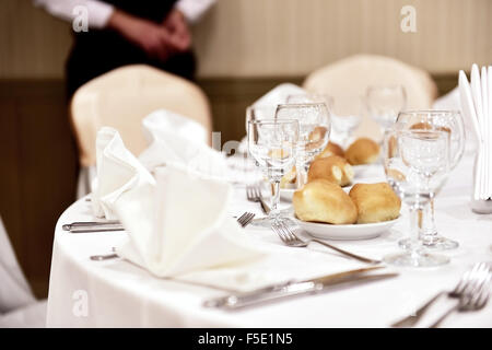 Posate dettaglio girato in un ristorante elegante tavolo con un cameriere in background Foto Stock