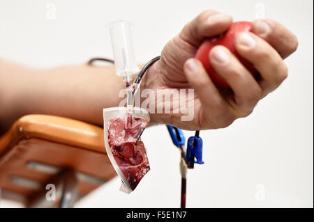 Dettaglio con la mano di un donatore di sangue e una plastica sacca di sangue in un ospedale Foto Stock