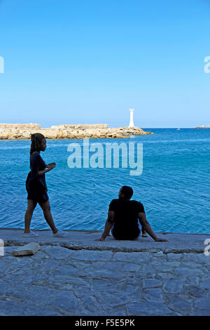 Persone sedute lungo la banchina all'entrata di Kyrenia porto di Cipro Nord KATHY DEWITT Foto Stock