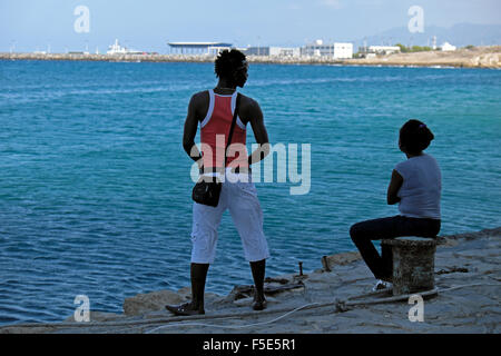 Turisti persone seduti lungo la banchina all'ingresso del porto di Kyrenia a Cipro Nord KATHY DEWITT Foto Stock