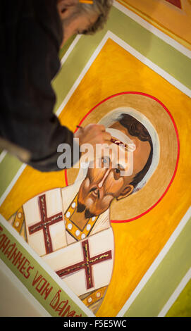 Francoforte, Germania. 27 ott 2015. Artista Oleg Kuzenko dipinge un quadro di san Giovanni Crisostomo presso la chiesa bizantina in costruzione presso la Scuola di Dottorato di filosofia e di teologia di Sankt Georgen in Frankfurt, Germania, 27 ottobre 2015. Un ex casa di storage nei locali è stato convertito in un riccamente illustrato chiesa. Foto: Frank Rumpenhorst/dpa/Alamy Live News Foto Stock