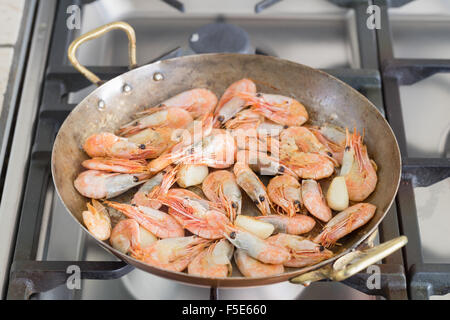 I gamberi in una padella di rame su un fornello a gas Foto Stock