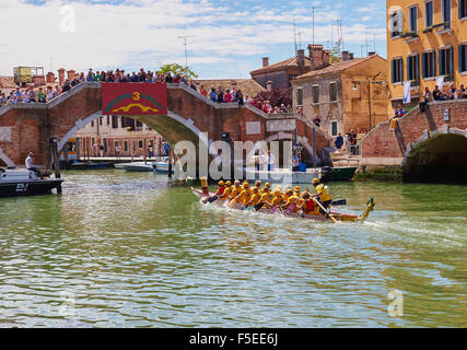 Un team di prendere parte alla Vogalonga raggiungono il punto di finitura in Canale di Cannaregio guardato da folle su un ponte Venezia Italia Foto Stock