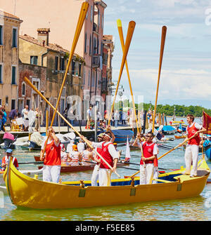 Un team di prendere parte alla Vogalonga tenere i loro remi in aria per celebrare la finitura Canale di Cannaregio Venezia Veneto Italia Foto Stock