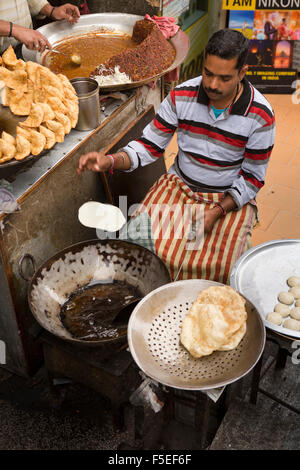 India, Himachal Pradesh, Shimla (Simla), Mall Road, uomo gettando paratha disco di pasta in karahi di olio caldo Foto Stock