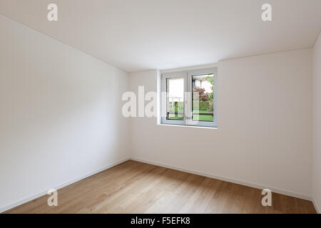 Interno del nuovo appartamento, ampia camera con finestra, pavimento in parquet Foto Stock