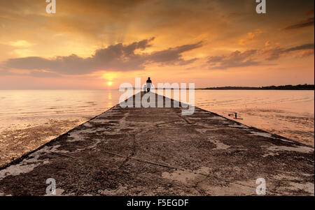 Silhouette di un uomo e suo figlio in piedi alla fine di un pontile, Port Dickson, Malaysia Foto Stock