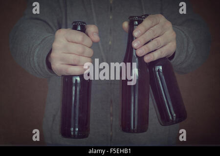 Close-up di uomo con bottiglie di birra Foto Stock